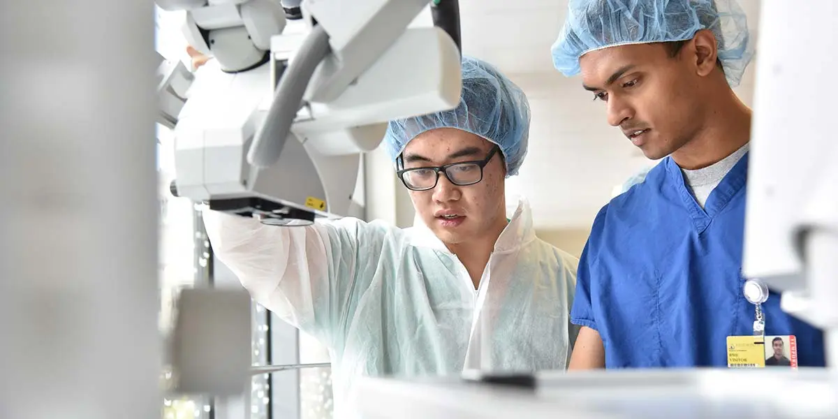 Two students working with a biomedical machine